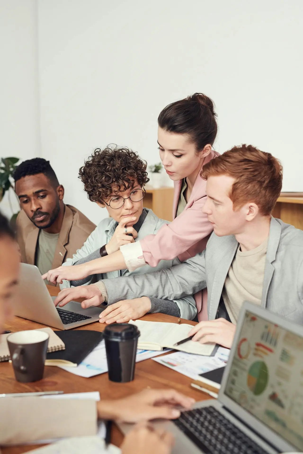 A diverse team of young developers collaborating on a tech project in a modern workspace